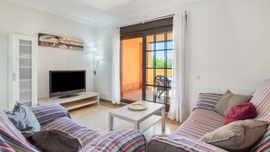 A living room with a TV, sofa, and a table. - Apartment 'Albatros' with Shared Pool, Private Terrace and Wi-Fi (Ayamonte)
