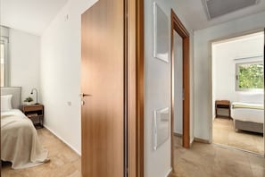 A bedroom with a bed, bedside table, and a window.
