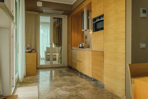 A modern kitchen with wooden cabinets, a stainless steel range hood, and a built-in oven. -  Hotiday Lodge Cecina (Cecina)
