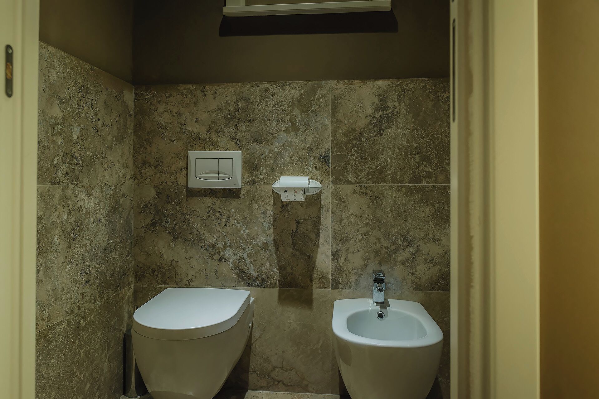 Un baño pequeño con dos orinales y un inodoro.