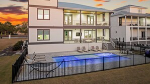 A multi-story building with a pool area, outdoor seating, and a balcony. - Rising Tide | Private Pool/Spa | 6-Seater Golf Cart | Private Beach Access (Miramar Beach)