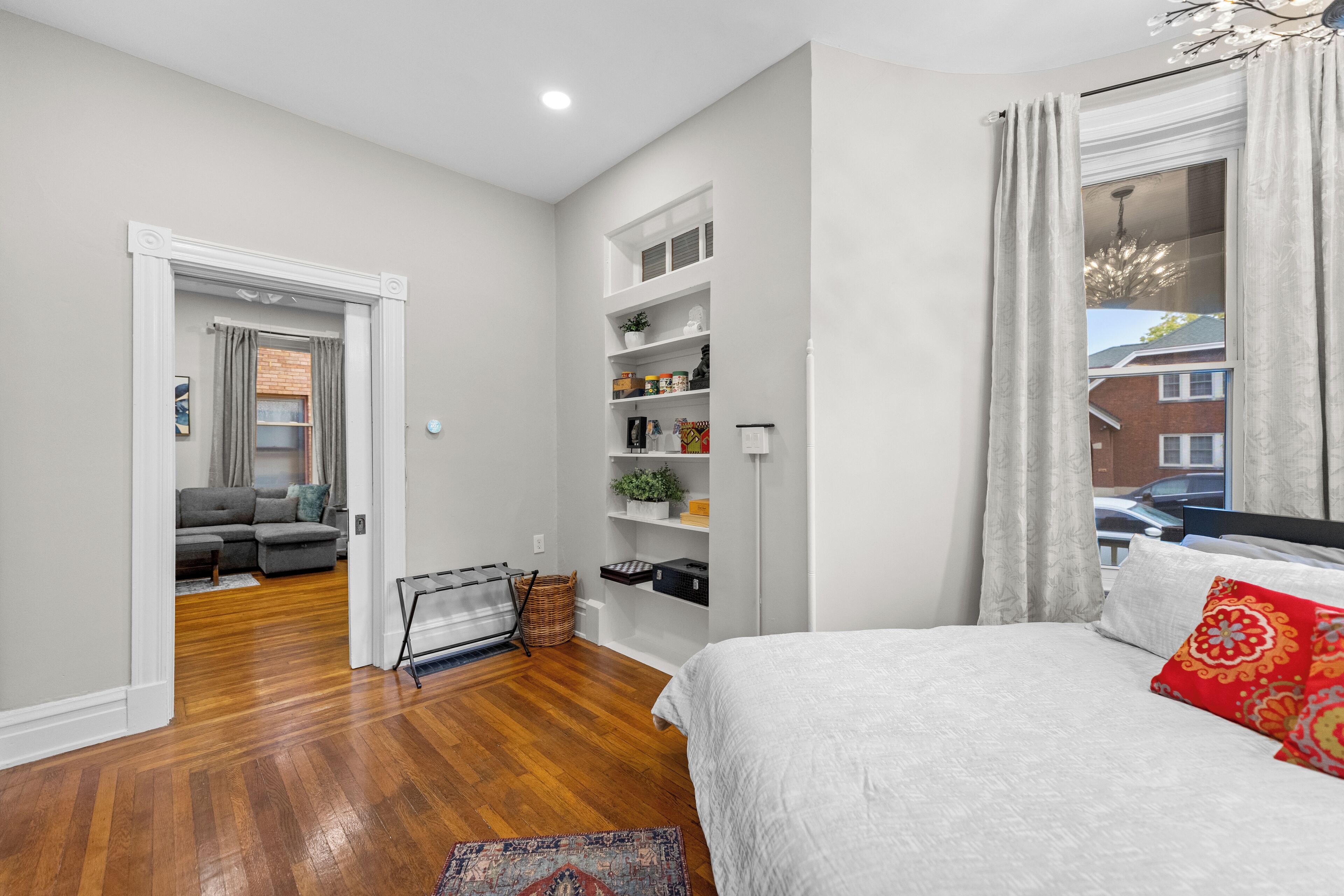 Quarto com cama, armário embutido e janela com cortinas.