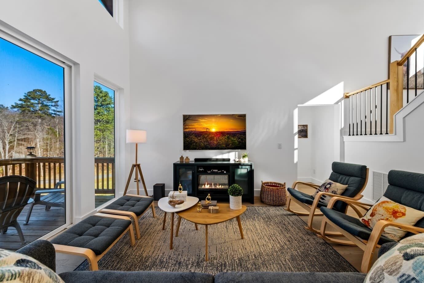 Un salon moderne avec une cheminée, des sièges confortables et un grand téléviseur fixé au mur.