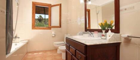 A bathroom with a bathtub, toilet, and sink.