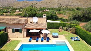 Uma villa com piscina, área de estar ao ar livre e vista para as montanhas.