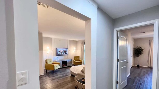 A modern living room with a sofa, armchairs, a TV, and a dining area. - Chic Chateau-Less than 2 miles to the strip! (Branson)