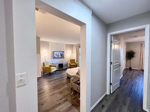 A modern living room with a sofa, armchairs, a TV, and a dining area. - Chic Chateau-Less than 2 miles to the strip! (Branson)