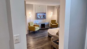 A modern living room with a sofa, two armchairs, a fireplace, and a television. - Chic Chateau-Less than 2 miles to the strip! (Branson)