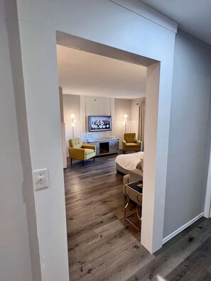 Un salon moderne comprenant un canapé, deux fauteuils, une cheminée et un téléviseur.