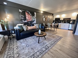 Uma sala de estar moderna com sofá, mesa de centro e tapete estampado.