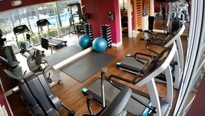 Une salle de sport équipée de tapis de course, de ballons d'exercice et d'appareils de musculation.