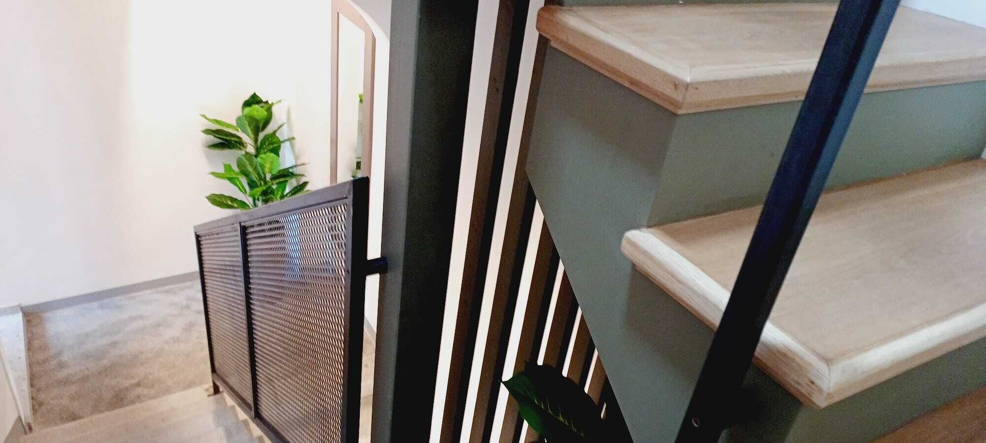 Una escalera con escalones de madera y barandilla metálica.