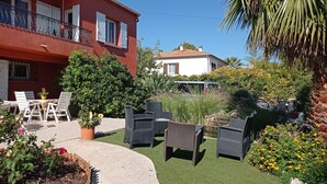 A courtyard with outdoor furniture, a small table, and potted plants.
