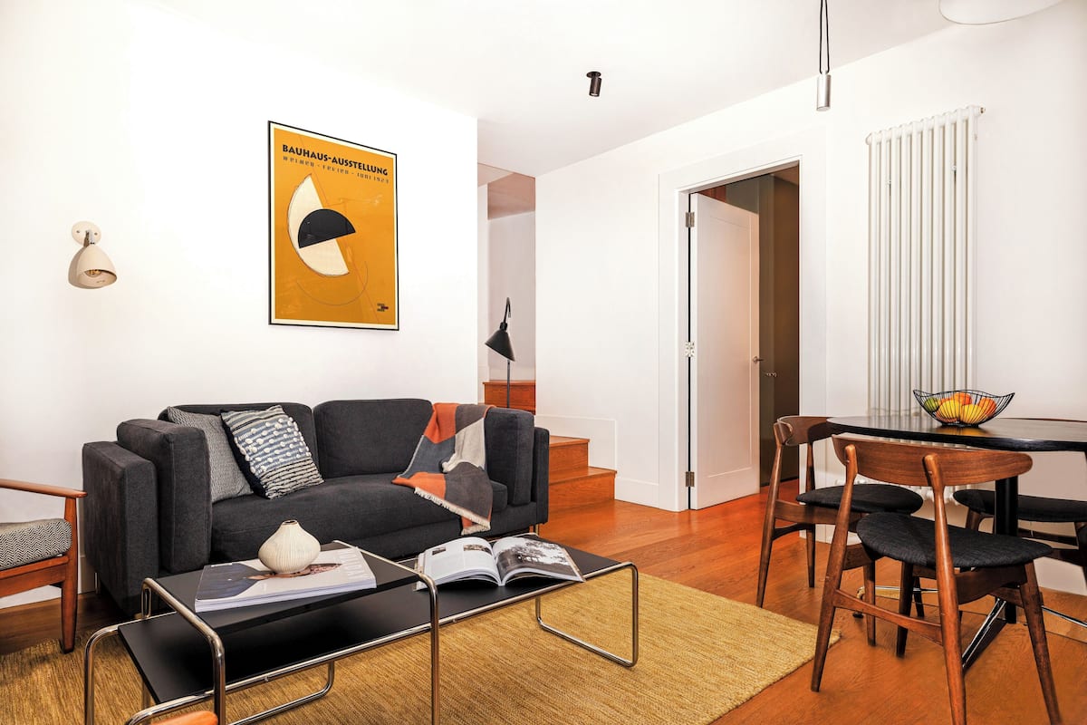 A modern living room with a sofa, coffee table, and dining area.