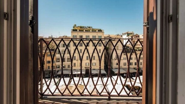 An open balcony with a wrought iron railing, offering a view of a building with multiple windows and balconies. - Campo 8 - Spacious Apartment with View of Campo dè Fiori (Roma)