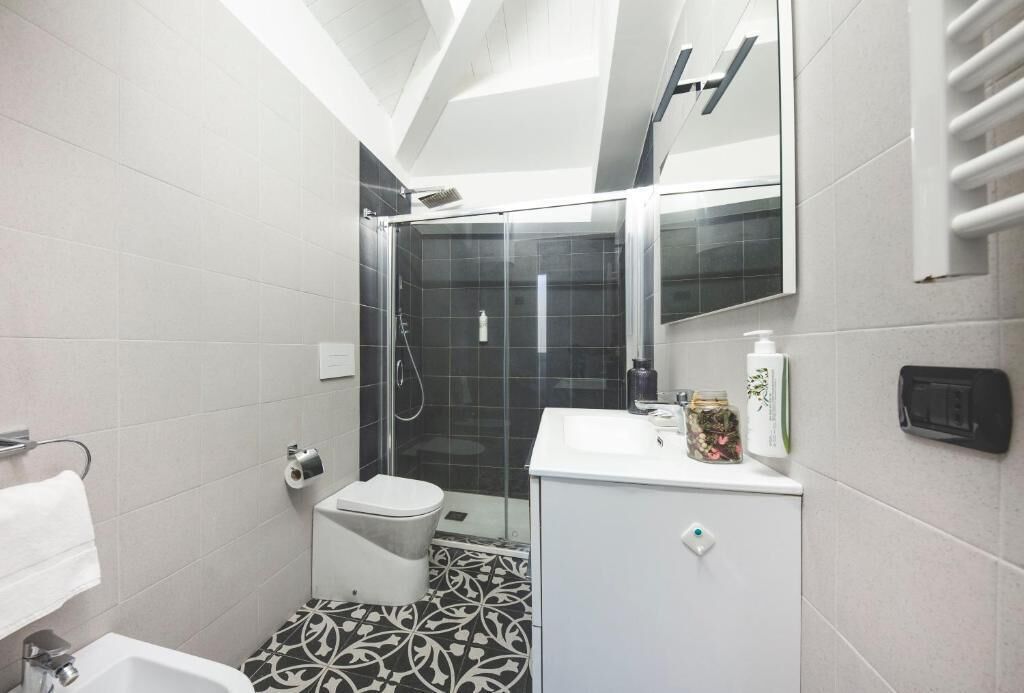 Un bagno compatto con doccia, WC e lavandino.