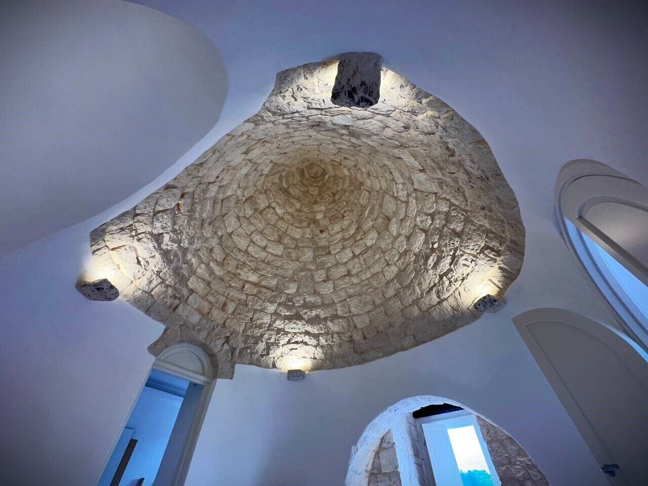 A stone ceiling with a circular pattern and a central light fixture.