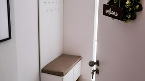 A corner room with a bunk bed, a welcome sign, and a small shelf unit.