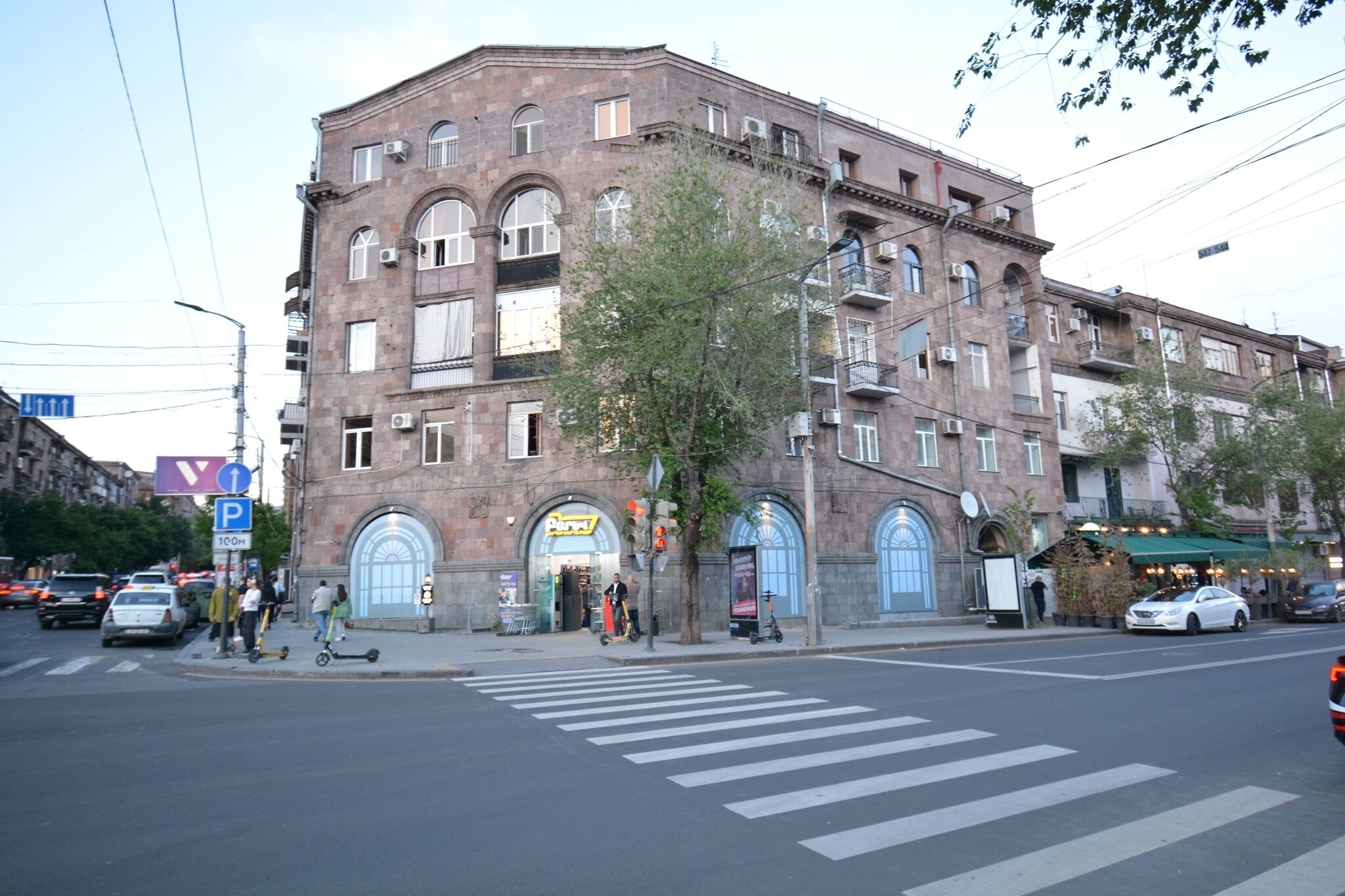 A multi-story building with a classic architectural style, featuring arched windows and a central entrance.