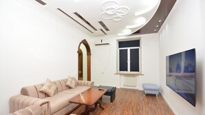 A modern living room with a sofa, a coffee table, and a television.
