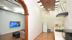 A compact kitchen with a stove, microwave, and refrigerator.