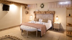 Une chambre à coucher avec un grand lit, des tables de chevet, une tête de lit en bois et une petite étagère.