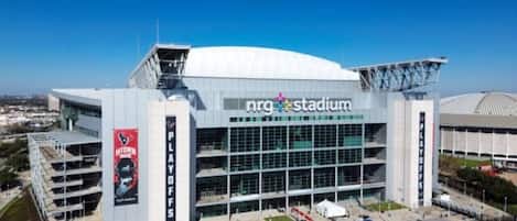 Ein modernes Stadion mit mehreren Sitzebenen und einem gut sichtbaren Schild mit der Aufschrift 'nrg Stadium'.