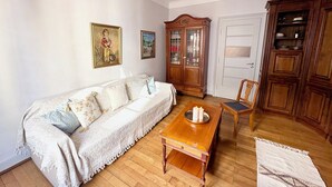 Un salon avec un canapé, un meuble en bois et une table à manger.