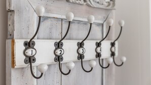 A wall-mounted coat rack with numbered hooks.