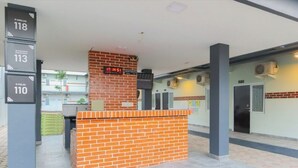 A reception area with a brick counter, a digital clock, and numbered signs indicating room numbers. - Puspiptek Residence Syariah (South Tangerang)