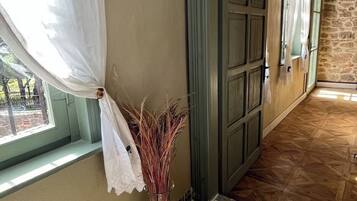 Un passadís amb terra de sisquet, un vas amb plantes seques i un felpó.
