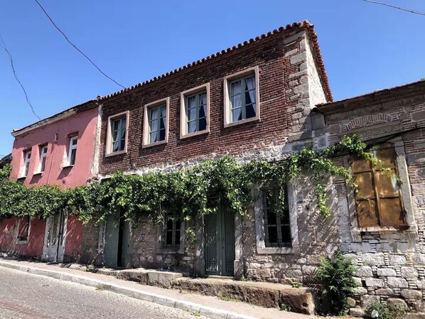 A row of historic buildings with stone facades and traditional windows, some with vines growing over them. - A historic stone house, Ideal for visitors to the Acropolis-Asklepion in Bergama (İzmir)