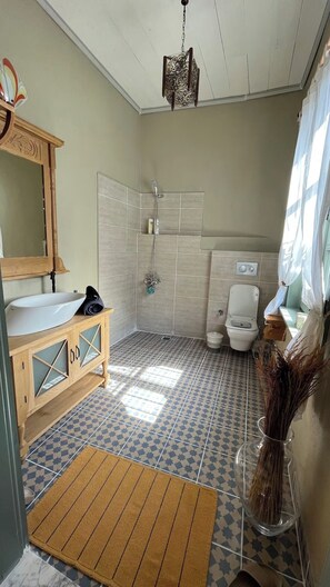 A bathroom with a wooden vanity, a shower, a toilet, and a decorative hanging light fixture. - A historic stone house, Ideal for visitors to the Acropolis-Asklepion in Bergama (İzmir)