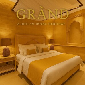 A luxurious bedroom with a large bed, two bedside tables, and a decorative mirror. - Hotel Grand Haveli Jaisalmer (Jaisalmer)