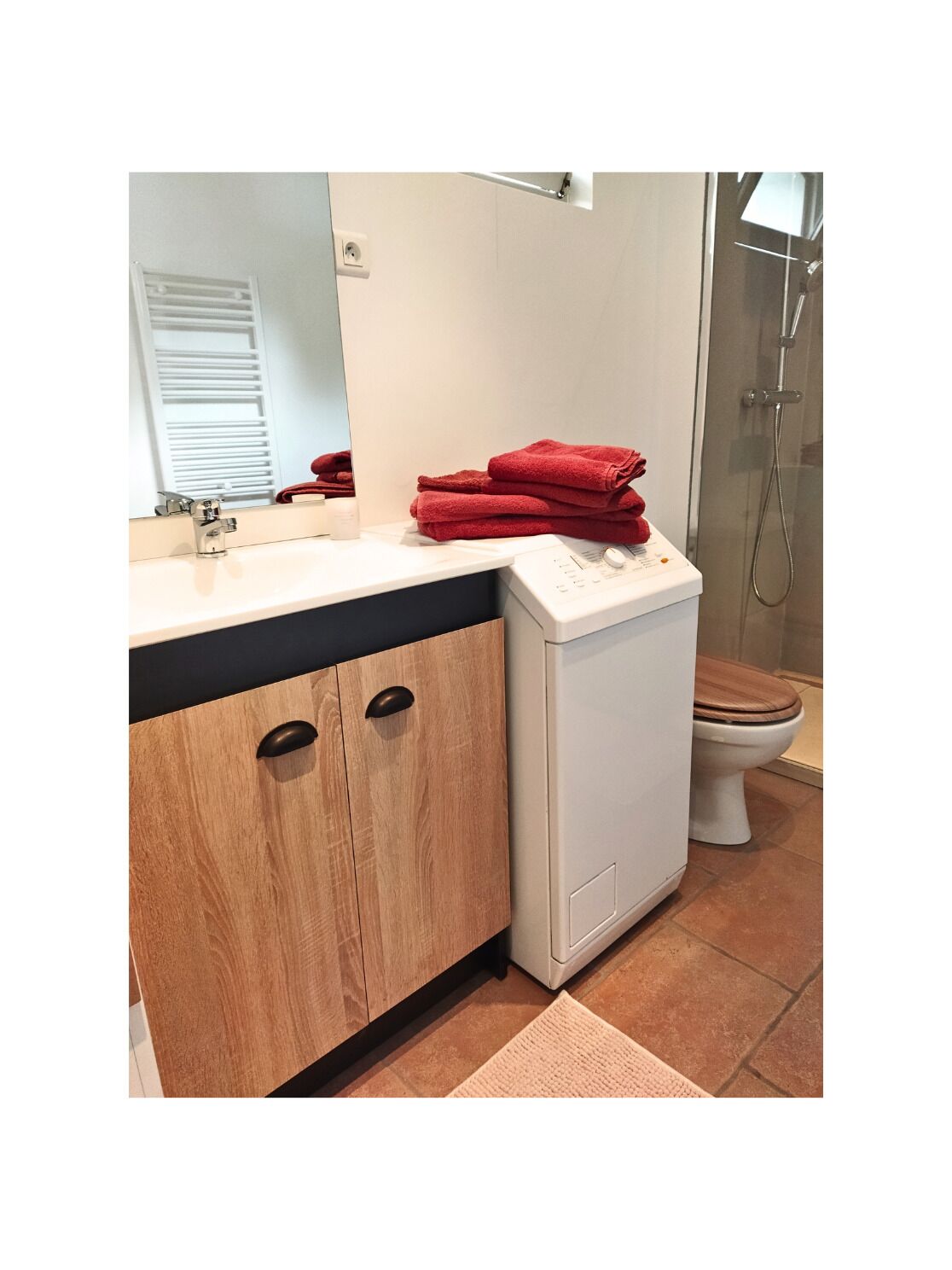 Een douche, handdoeken, zeep, toiletpapier