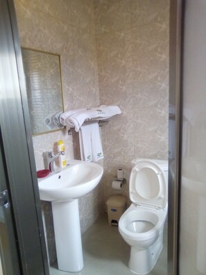 A bathroom with a sink, toilet, and towel rack. - Hotel Sidia (Catumbela)