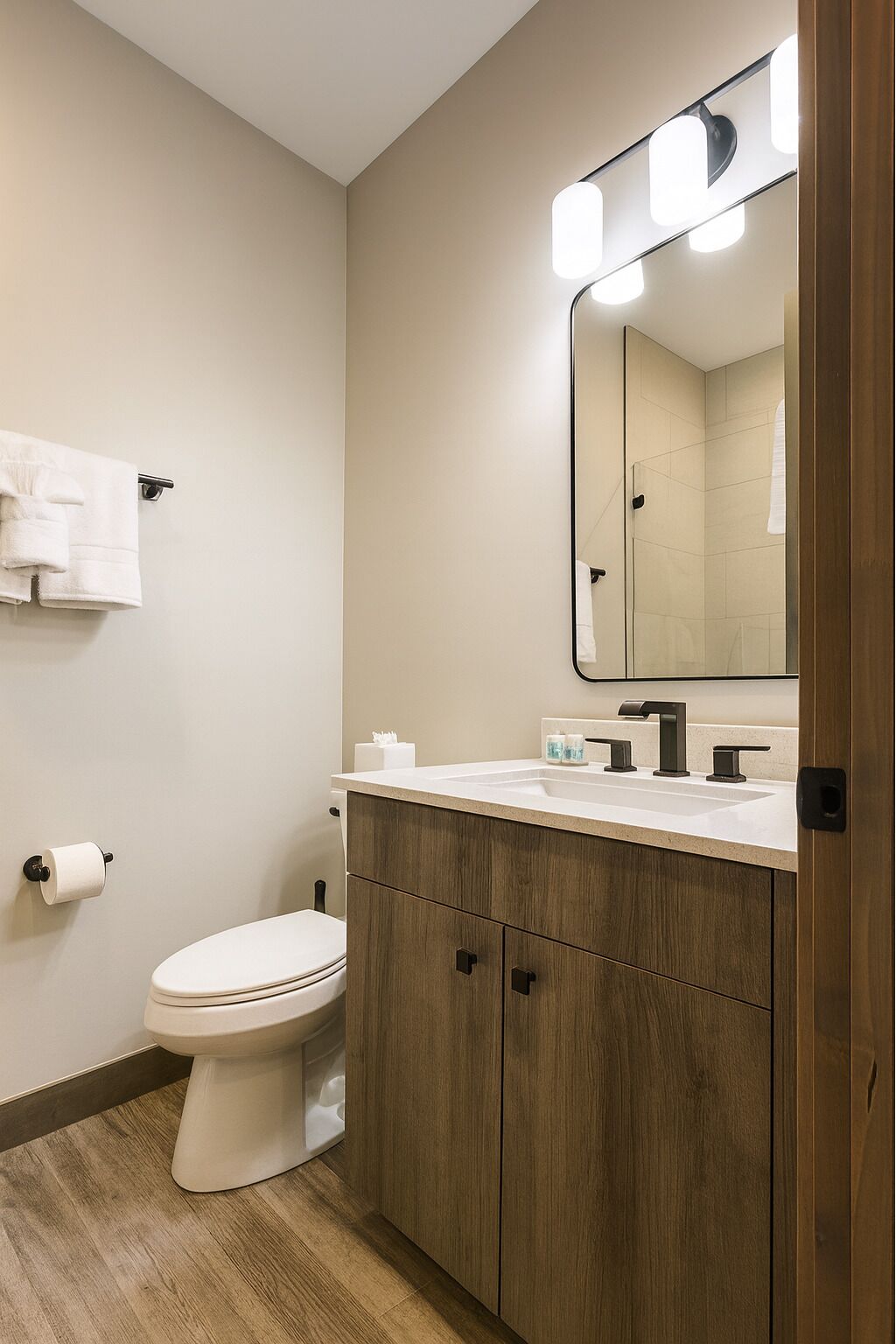 A modern bathroom with a toilet, sink, and mirror.