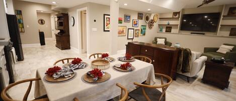 A dining area with a table set for four, surrounded by wooden chairs.