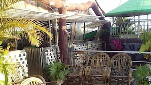Un espace extérieur aménagé avec des chaises en osier et des plantes en pot.