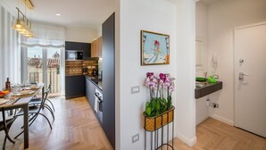 A modern kitchen with a dining area, a view through the window, and a wall-mounted orchid planter. - New Luxury Penthouse 2 steps from downtown (Firenze)