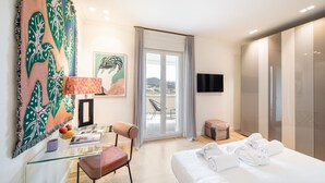 A hotel room with a bed, a desk with a chair, a television, a window with a view, and a sliding door. - New Luxury Penthouse 2 steps from downtown (Firenze)