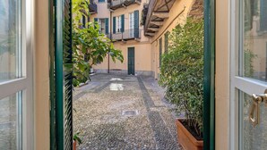 Un callejón estrecho con un sendero adoquinado, un vano de puerta y una maceta.