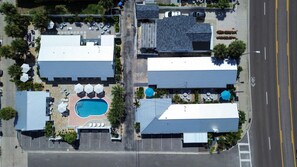 Vista aérea de um hotel com vários edifícios, piscina e áreas de estar ao ar livre.