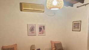 Quarto com duas camas, uma mesa de cabeceira, luminária e decoração na parede.