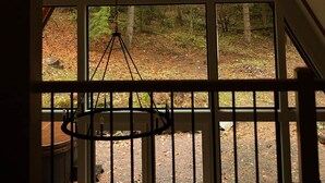 Una habitación con un ventanal que ofrece vistas a un área boscosa.