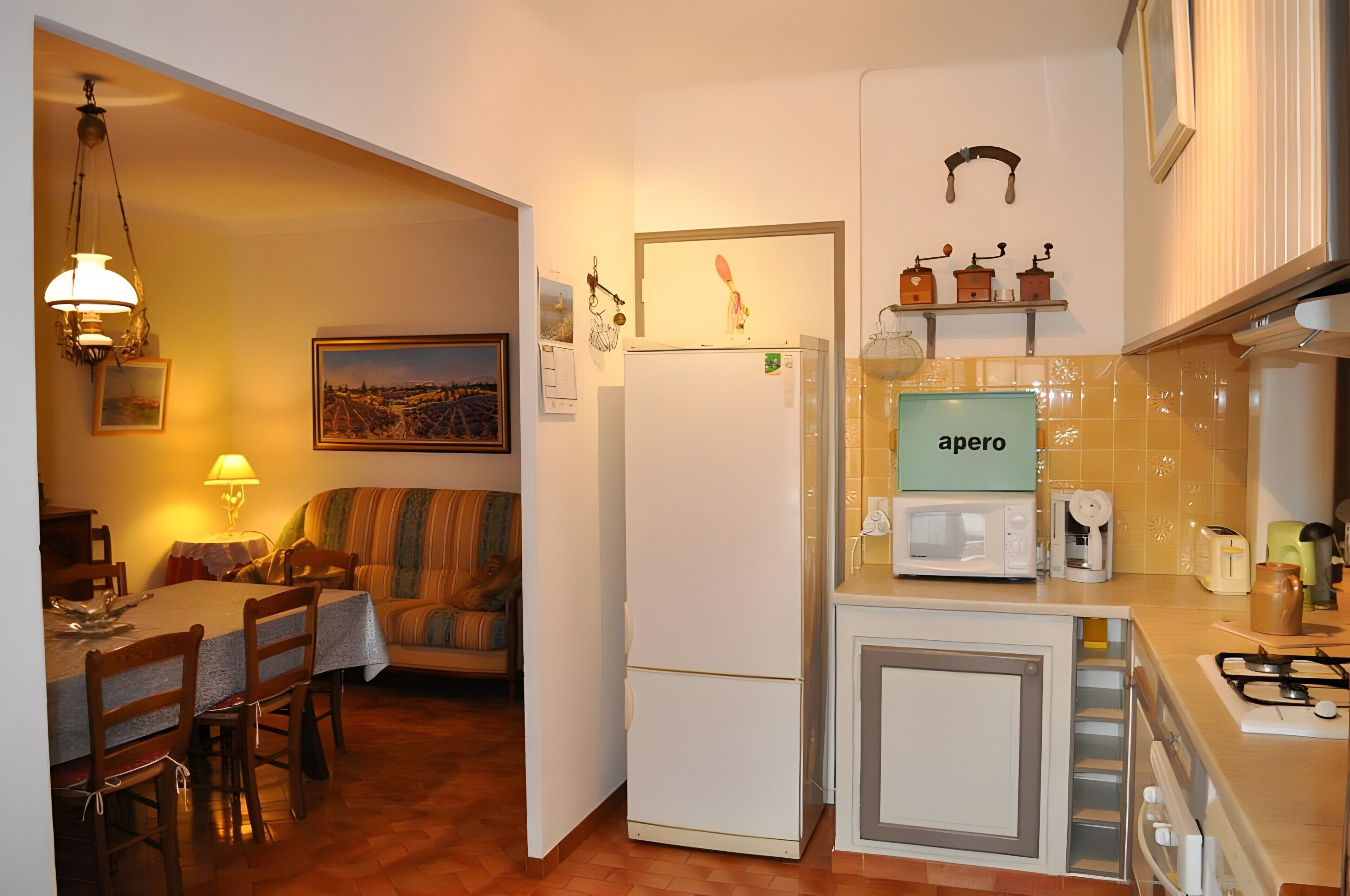 Eine kleine Küche mit Kühlschrank, Mikrowelle und einem Schrank.