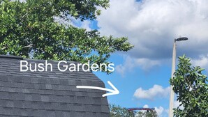 En liten byggnad med vit fasad och mörkt tak, med skylten ”Bush Gardens”.