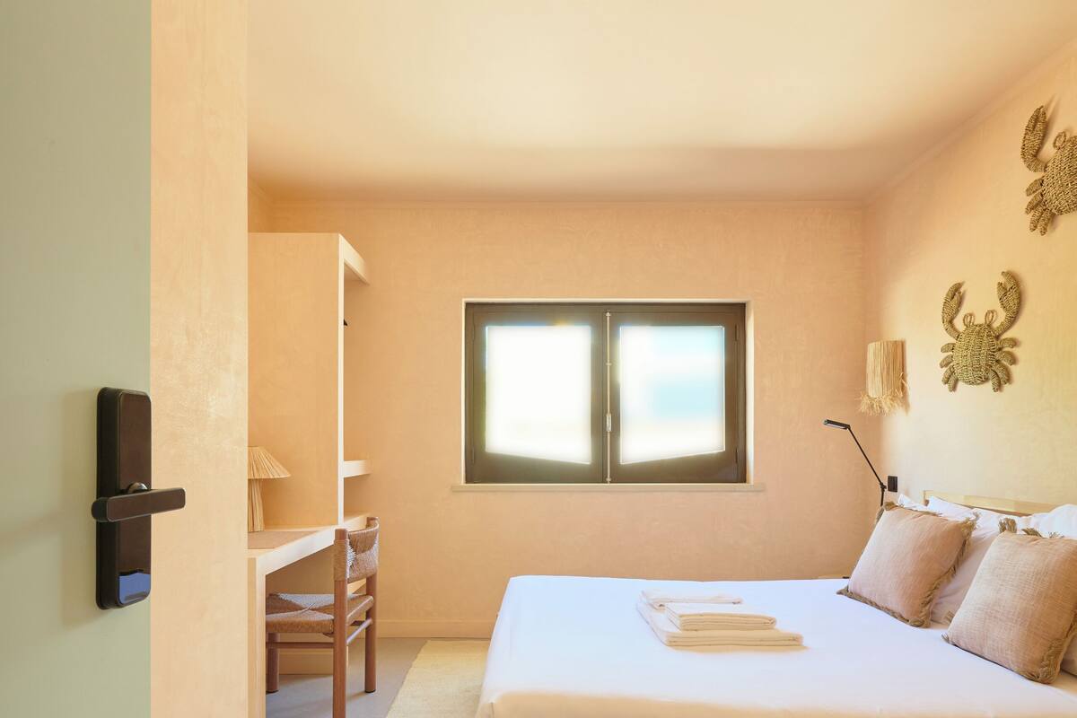 Un dormitorio con una cama, un escritorio y una silla.