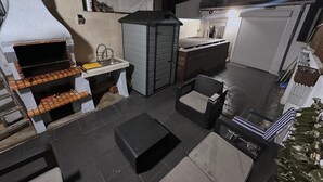 Een kleine keuken met een ingebouwde grill, een klein spoelbakje en een compacte koelkast.