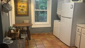 A compact kitchen with a window, a dining table, and a refrigerator. - Peaceful 2-bedroom house in charming Trussville (Trussville)